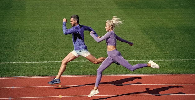 Couple de sport d'entraînement extrême courir vite pour gagner des sprinters de fitness réussis homme athlétique et femme sexy s'affrontent dans le sprint masculin et féminin sur la piste de course du stade mode de vie sain vitesse de marathon