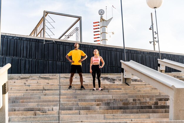 Couple sportif multiethnique s'entraînant en plein air