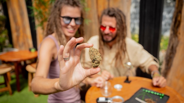 Un couple de style hippie examine les articulations et les bourgeons de marijuana médicale