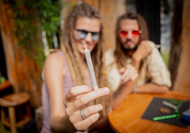 Couple de style hippie fumant des cigarettes avec de la marijuana médicale