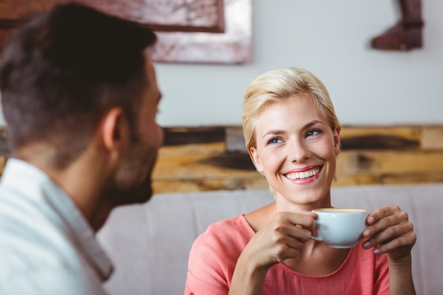 Couple avec une tasse de café assis sur le canapé