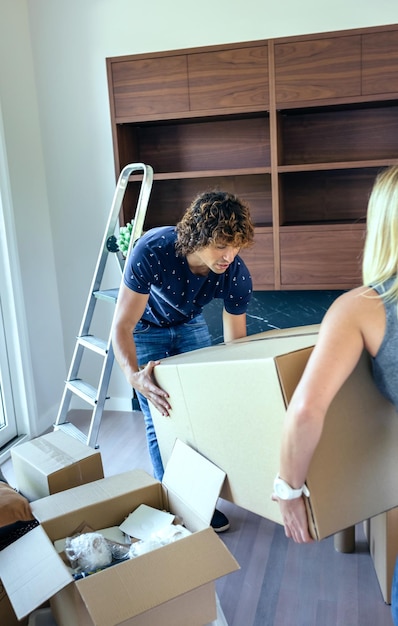 Un couple tenant une boîte en carton à la maison