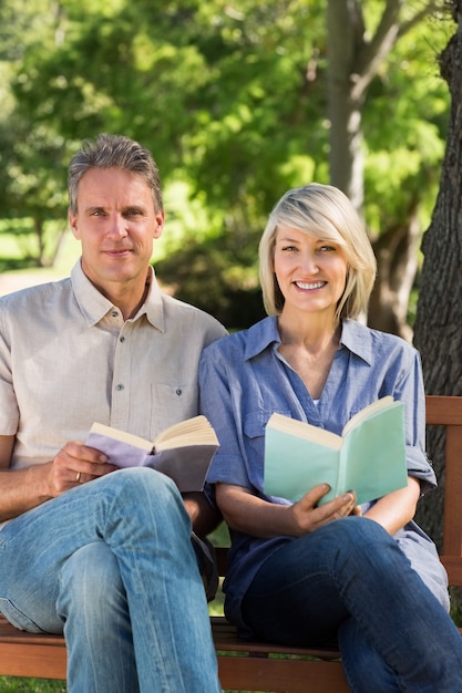 Couple tenant des livres dans le parc