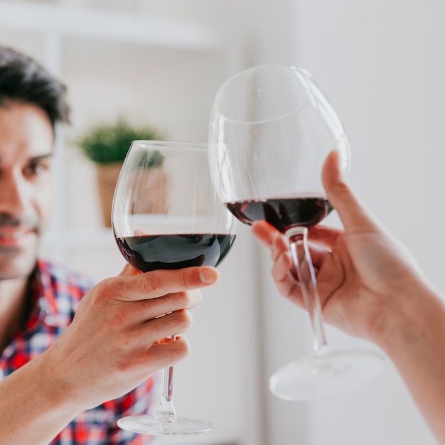 Photo couple tinter les verres de vin rouge