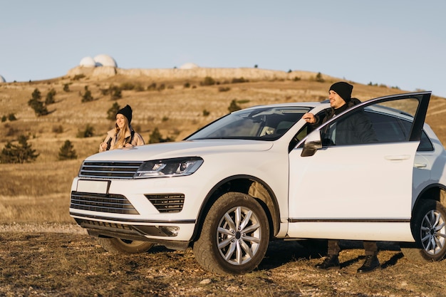 Couple de tir complet avec voiture dans la nature