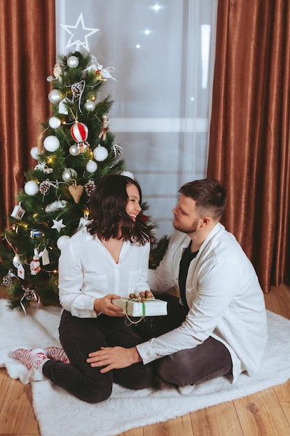 Couple tirant devant la carte-cadeau de l'espace de copie d'arbre de noël décoré