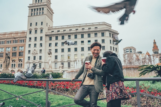 Couple de touristes asiatiques en riant de colombes