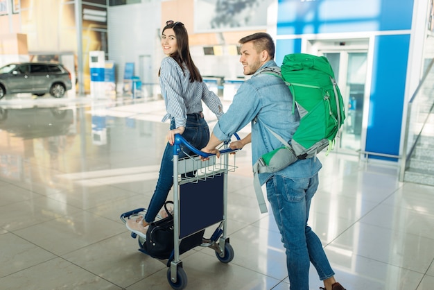 Couple De Touristes Avec Chariot Et Bagages à L'aéroport.