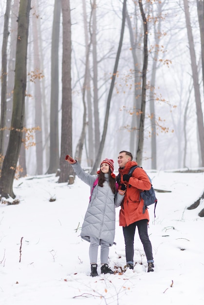 Couple de touristes debout sur la montagne et admire les paysages de neige