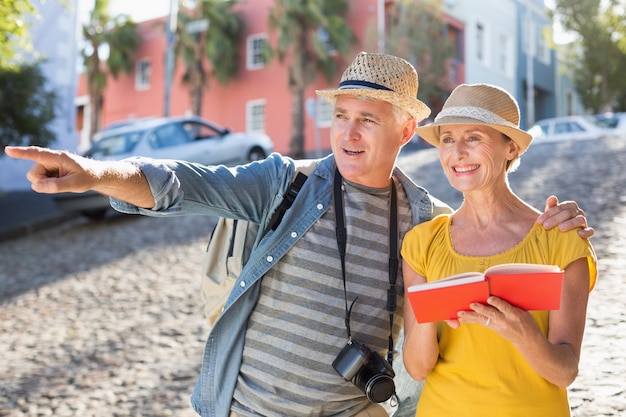 Couple de touristes heureux à l&#39;aide d&#39;un guide dans la ville