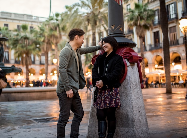 Couple de touristes heureux asiatiques parler dans un carré