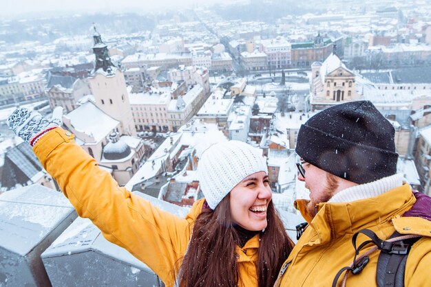 Couple de touristes prenant un selfie avec une belle vue sur la ville en hiver sur fond