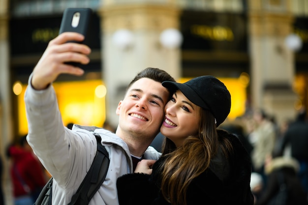 Couple de touristes prenant un selfie dans la ville