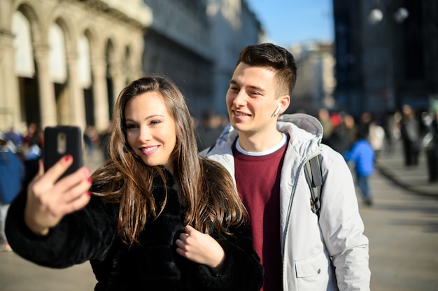 Couple de touristes prenant des selfies à Milan