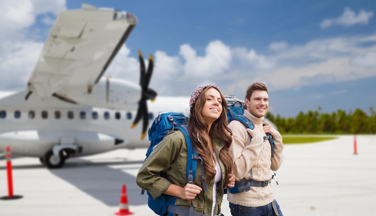 Photo couple de touristes avec des sacs à dos sur l'avion