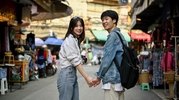 Un couple de touristes se tenant la main tout en visitant la vieille ville de Chiang Mai