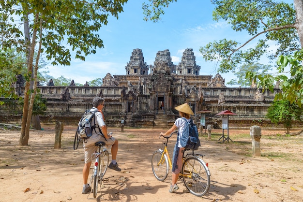 Couple de touristes à vélo autour du temple d&#39;Angkor, Cambodge. Ruines de Ta Keo