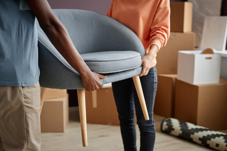 Photo couple transportant des meubles dans un nouvel appartement