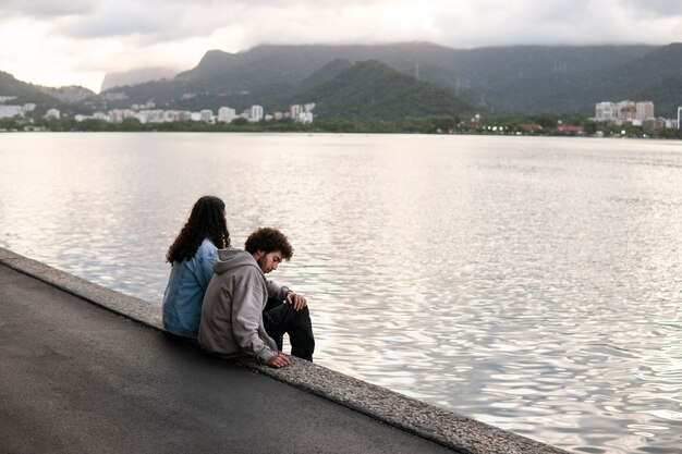 Photo couple triste et contemplatif au bord du lac