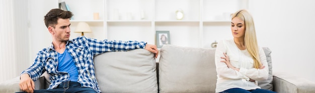 Le couple triste est assis sur le canapé