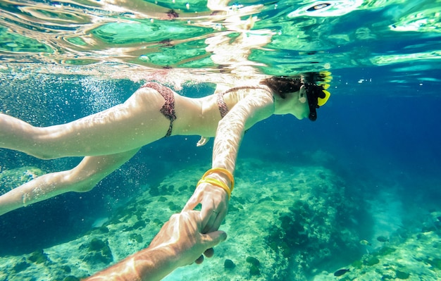 Couple de tuba nageant ensemble dans une mer tropicale avec suis moi composition