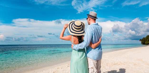 Couple en vacances marchant sur une plage tropicale aux Maldives. Homme et femme promenade romantique sur la plage.