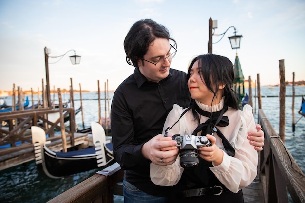 Couple en vacances à Venise se blottir ensemble se regardant dans les yeux et tenant la caméra