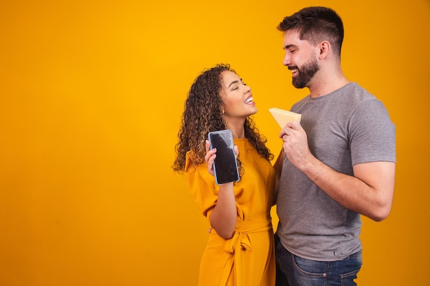 Couple de Valentine faisant campagne pour la marque de fromage. Happy Valentine couple avec fromage et téléphone portable avec écran vide