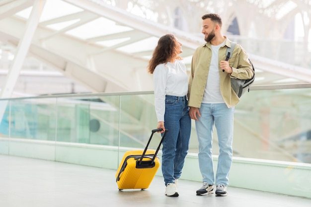 Un couple avec une valise au terminal de l'aéroport