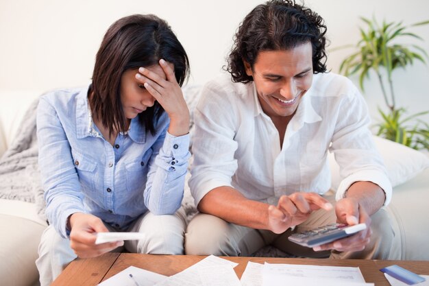 Couple vérifiant leurs factures dans le salon