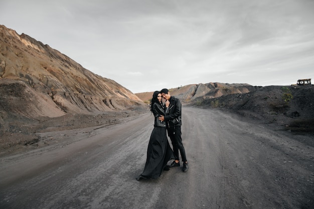 Couple en vêtements de cuir noir posant dans la nature