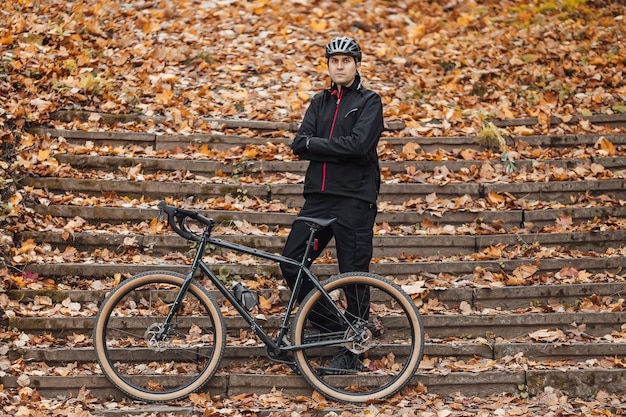 Couple de vététistes à vélo sur piste cyclable dans la forêt d'automne VTT dans la forêt de paysage d'automne