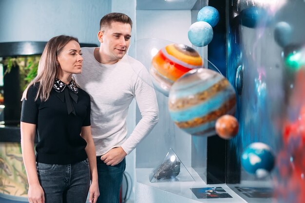 Le couple voit l'exposition des planètes du système solaire dans le Museumm.