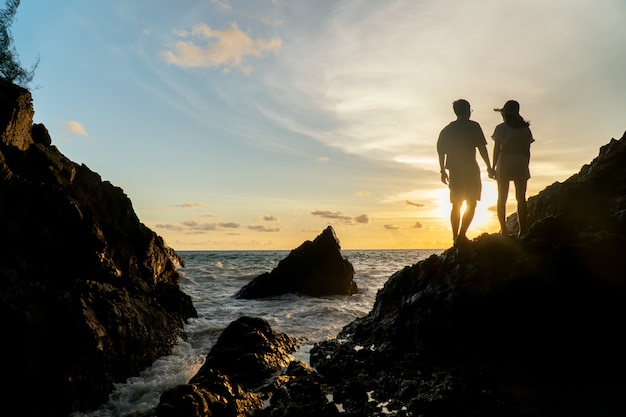 Couple voyage au coucher de soleil sur la plage