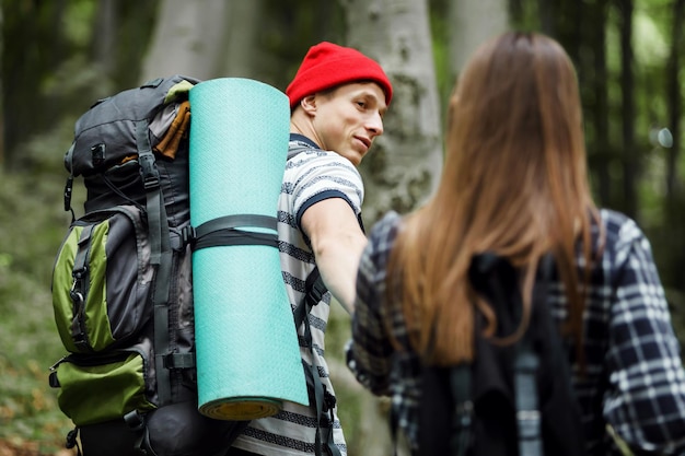 Couple de voyage avec carte et sacs à dos dans la forêt liberté et concept de voyage actif