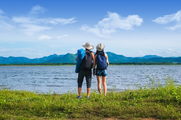 couple voyageur debout près du lac dans la montagne