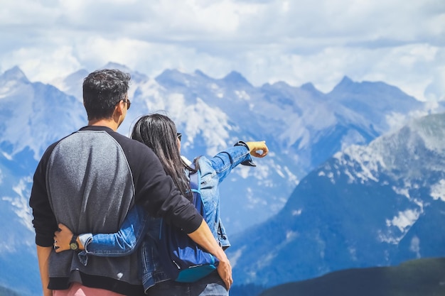 Un couple de voyageurs admirant le paysage des montagnes des Alpes.