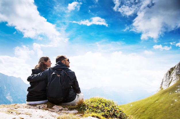 Couple de voyageurs au sommet d'une montagne bénéficiant d'une vue sur la vallée Voyage Vacances Liberté Concept