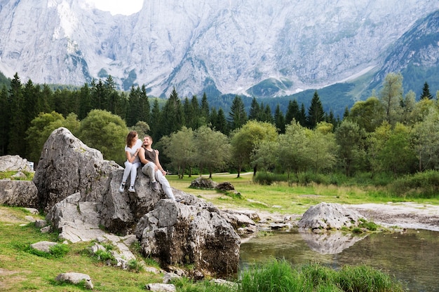 Couple de voyageurs sur le lac Lago di Fusine avec les montagnes Mangart en arrière-plan