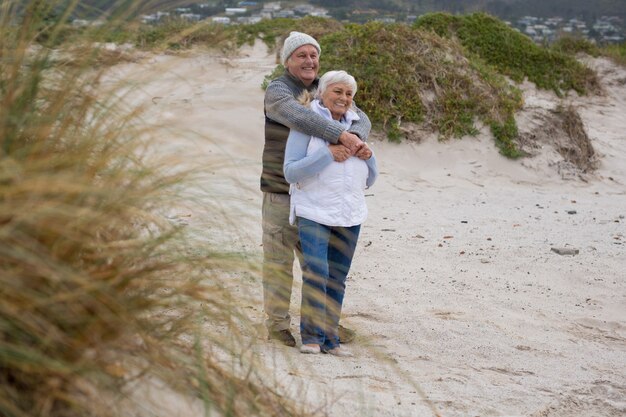 Couples aînés, debout, ensemble, plage