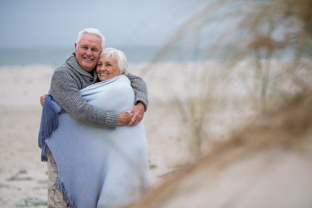 Couples aînés, enveloppé, dans, châle, plage