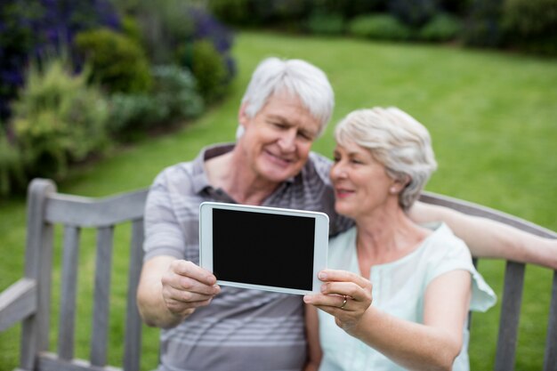 Couples aînés, séance banc, et, tenue, tablette numérique