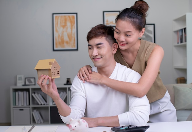 Les couples asiatiques économisent de l'argent pour acheter une nouvelle maison les amoureux économisent de l'argent pour la sécurité future