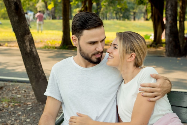 Couples assis et étreignant dans le parc.