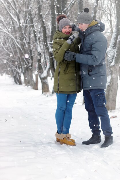 Les couples de famille marchent la neige d'hiver