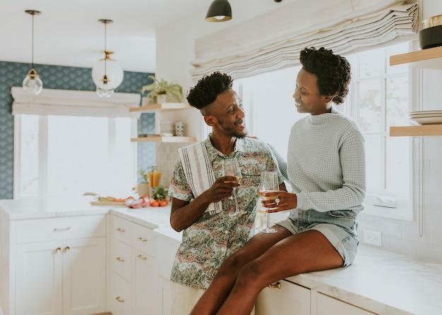 Couples heureux dégustant un verre de vin dans la cuisine