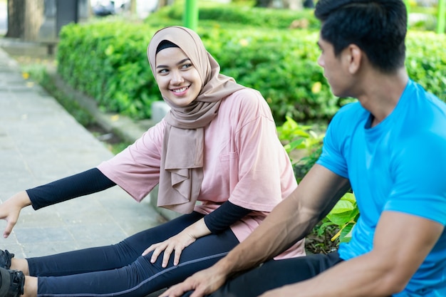 Les couples musulmans s'assoient et se détendent pendant leur pause d'exercice dans le jardin