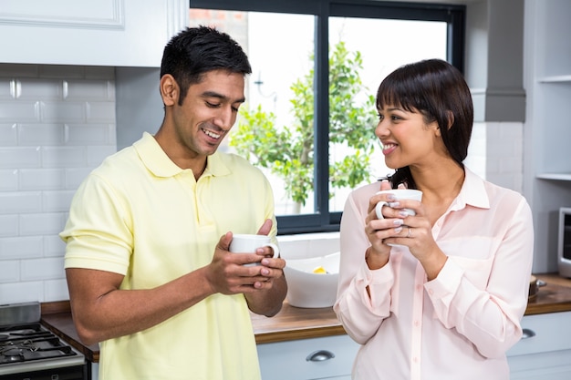 Coupletalking heureux et tenant des tasses