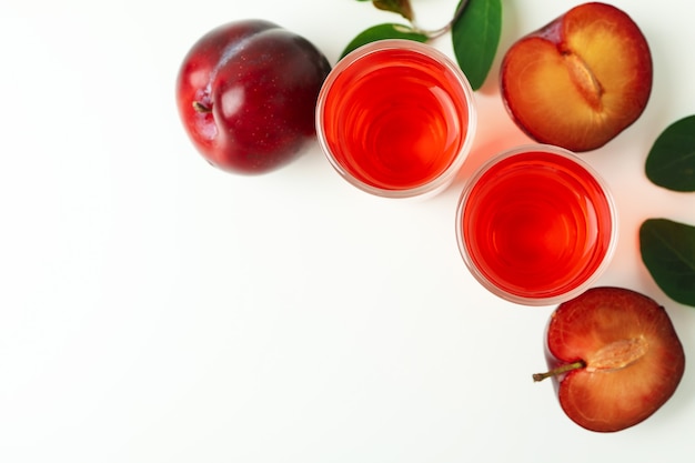 Coups de brandy de prune et ingrédients sur fond blanc