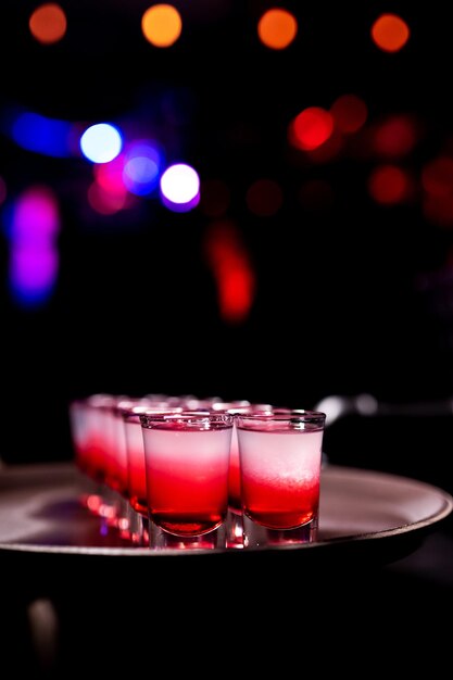 Des coups rouges prêts sur un plateau dans une boîte de nuit, mélangeant un cocktail alcoolisé dans un restaurant de pub de boîte.